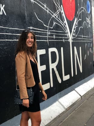 Student foran et veggmaleri i Berlin under utveksling i Tyskland, med fokus på urban kultur og dagligliv.